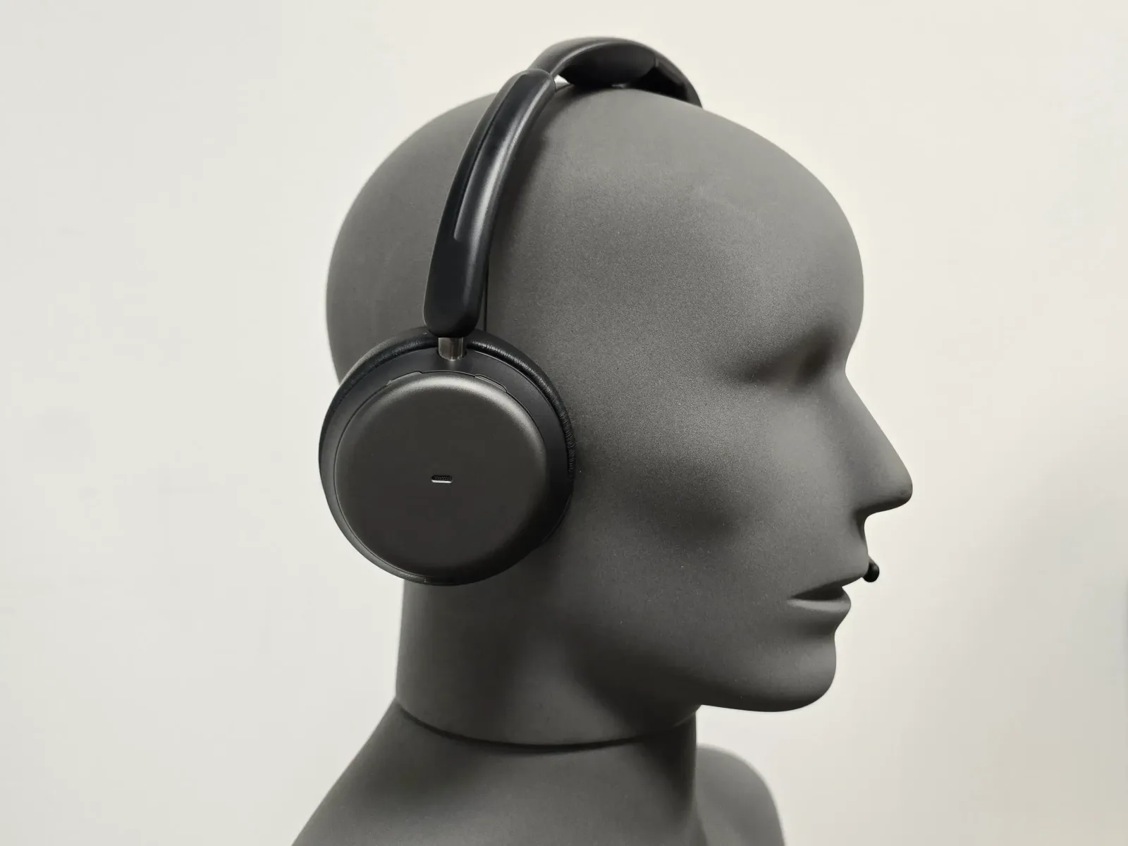 Casque de téléopérateur monté sur une tête artificielle de mesure, vu de profil sur fond neutre